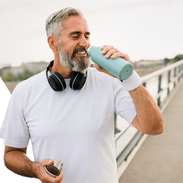 The Optavia coach is drinking water from a water bottle with a mild smile on his face